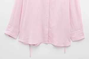 Detail of pink long sleeve shirt showing linen texture and white button accents