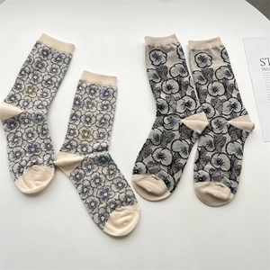 Detail view of retro floral jacquard pattern on beige vintage style cotton mid-calf socks