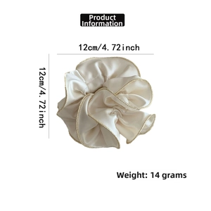 Vue détaillée du chouchou en satin crème de 12cm avec d'élégantes finitions dorées