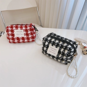 Detail of tweed fabric texture and pearl bead handle on red and black mini bags