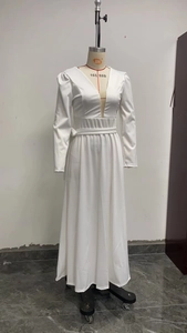 Dettaglio dell'elegante abito lungo bianco a maniche lunghe con scollo a V e cintura in vita