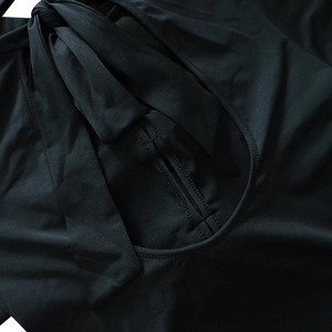 Détail d'une robe noire à manches longues avec des lacets et des découpes chics