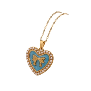 Vintage heart pendant necklace with blue enamel, bow detail, and imitation pearls