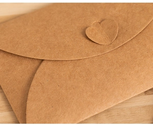 Close-up of vintage brown kraft paper envelope with a unique heart-shaped clasp closure