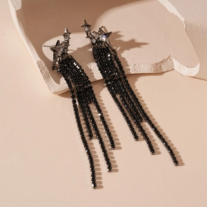 Detailed macro view of black star earrings with sparkling rhinestones and long tassel chains