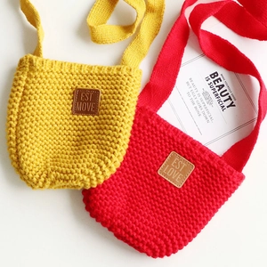 Dettaglio di mini borse a tracolla in maglia rossa e gialla con toppe in pelle marrone