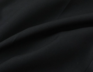 Gros plan sur la texture du tissu tissé noir de qualité pour cette veste de costume cintrée