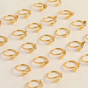 Detailed overhead view of various gold letter rings with heart charms from A to Z