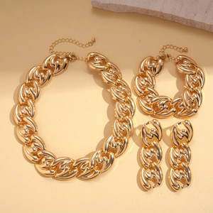 Detail view of a gold chunky chain jewelry set including a necklace, bracelet and earrings