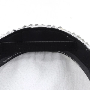 Close-up of black fabric lining and elastic band inside a silver sequin flat top hat