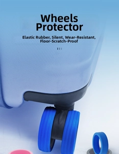 Close-up of pink and blue silicone suitcase wheel covers for noise reduction and protection