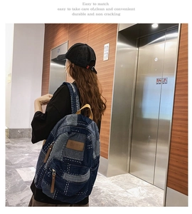 Deep blue denim backpack with vintage patchwork design shown in a casual lifestyle setting
