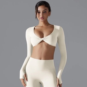 Dettaglio del set yoga con top corto con scollo a V, fori per i pollici e leggings a vita alta
