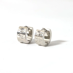 Detail of vintage wide hoop earrings in silver with engraved star patterns