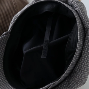 Detail of adjustable inner strap and breathable lining for grey checkered newsboy cap