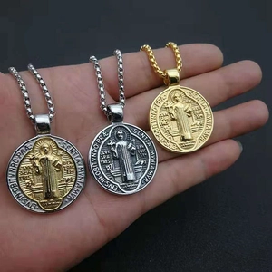 Detailed close-up of Saint Benedict medals in gold, silver, and two-tone metal finishes