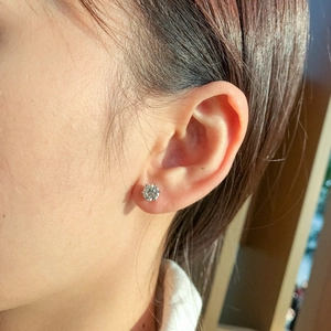 Detailed view of 925 sterling silver six-prong moissanite stud earring on a model