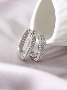 Macro shot of silver U-shaped huggie earrings with pave setting cubic zirconia stones