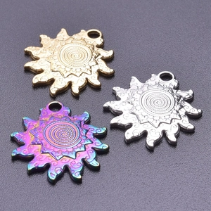 Macro detail of sun-shaped stainless steel pendants in gold, silver, and iridescent colors
