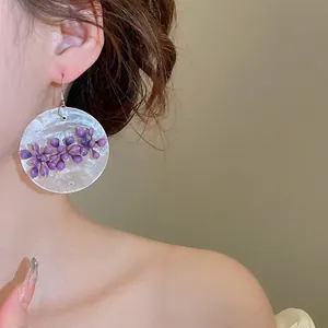 Asymmetric floral fringe earrings with purple petals and pearly shell base details