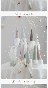 Detail of colorful plush Christmas gnomes with starry hats on festive white branches