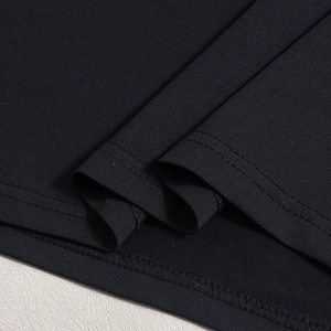 Gros plan détaillé du tissu en maille noire et des coutures précises sur la robe longue