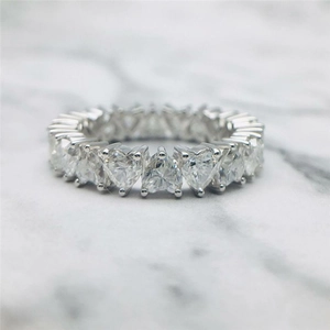 Sparkling heart-cut zircon eternity ring in silver finish on white marble background