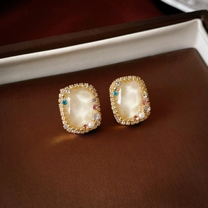 Close-up of vintage flower earrings with colorful zircons on a brown jewelry box