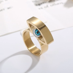 Detailansicht eines goldenen Edelstahlrings mit lebhaftem blauem Auge-Ornament