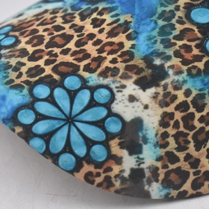 Macro view of leopard print fabric with blue floral patterns on a ponytail baseball cap