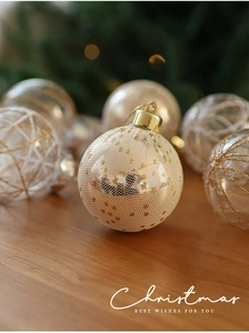 Detailed close-up of 6cm beige and gold Christmas baubles with glitter mesh texture