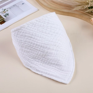 Close-up detail of white double-layer muslin cotton baby bib with soft gauze texture