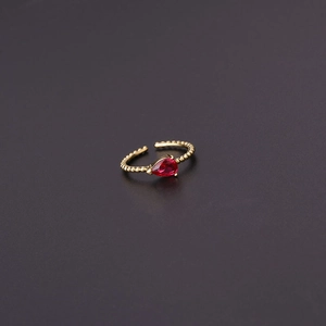 Detail of gold open ring featuring a pear-cut red zircon and beaded texture band