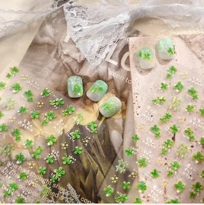 Detail of four-leaf clover nail stickers with green gradient finish and lace decor