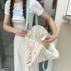 Detail view of floral canvas tote bag with large capacity and soft blue shoulder straps
