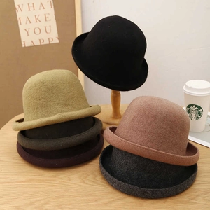 Detailed view of winter wool felt bucket hats in black, khaki, and brown on a wooden table