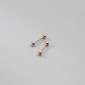 Détail macro de boucles d'oreilles s925 en argent poli or rose avec billes vissables