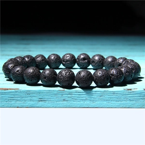 Close-up of black volcanic lava rock beads on a bracelet showing natural porous texture