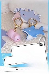 Detail of pink pig and blue shark couple keychains with gold metal lobster clasps