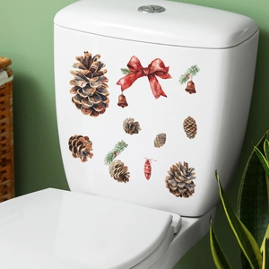 Christmas toilet tank decals with red bow, pine cones, and bells in a cozy bathroom setting
