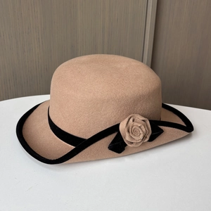 Détail d'un chapeau en feutre de laine camel avec rose faite main et ruban de velours