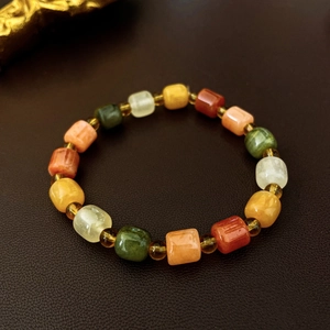 Macro shot of colorful cylindrical ceramic beads on bracelet with amber spacers on leather
