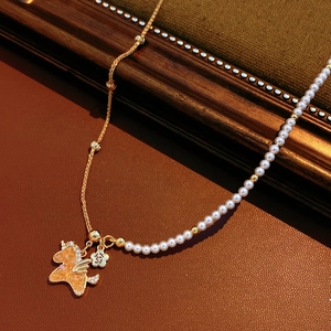 Detail of 18k gold plated necklace with pearls and zircon unicorn pendant on leather
