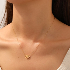 Collier minimaliste plaqué or avec double pendentif cœur porté sur le décolleté