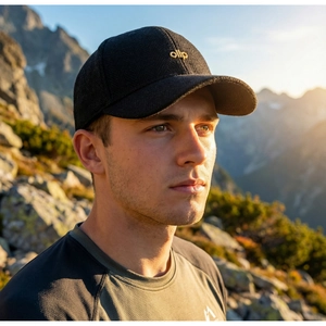 Close-up of black herringbone baseball cap with gold ollp embroidery and tweed texture