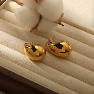 Boucles d'oreilles gouttes dorées en acier inoxydable poli dans un coffret à bijoux