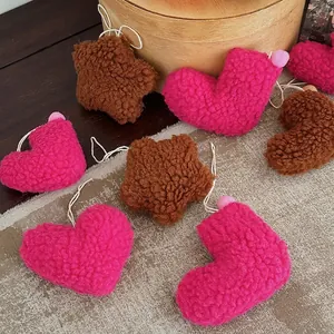 Plush heart and star Christmas ornaments in pink and brown teddy fleece on wood