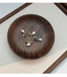 Close-up of knot design earrings with freshwater pearls in gold and silver finish
