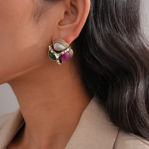 Close-up of vintage gold earrings with mixed teardrop opal and purple green gemstones