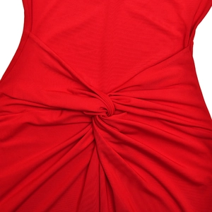 Detail of red elegant dress featuring intricate knot twist and soft pleated fabric texture